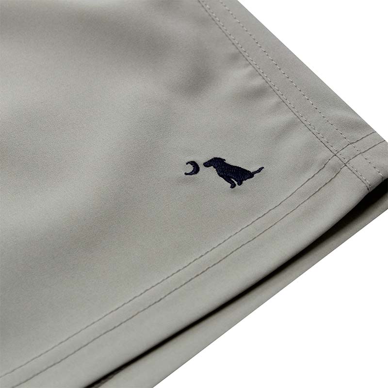 Close up of Local Boy Volley Shorts in Cool Grey. The sewn dog and moon logo on bottom leg of the short.